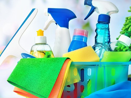 Ein blauer Plastikkorb mit verschiedenen Reinigungsmitteln und Utensilien drin
